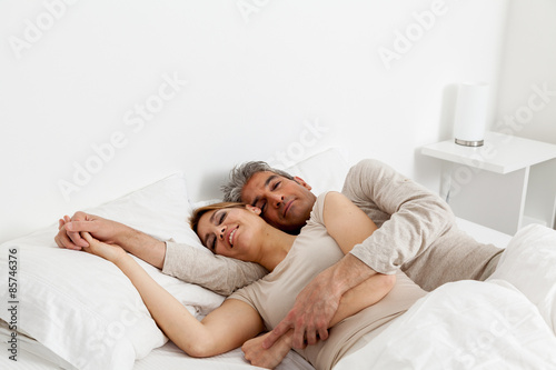 Couple sleeping in his bed