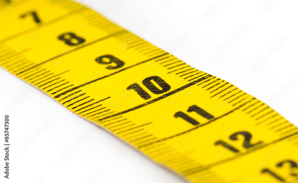 Yellow measuring tape isolated - selective focus Yellow measuring tape isolated - selective focus