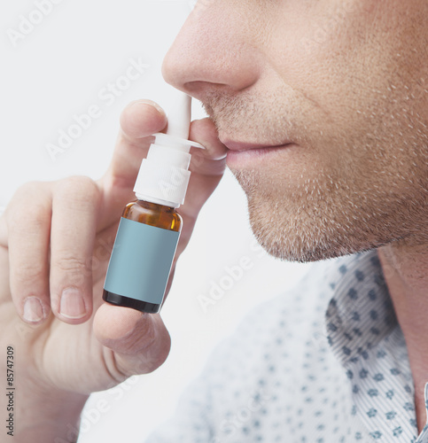 Naso con spray nasale in narice uomo photo