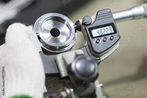 operator inspection automotive part by micrometer photo