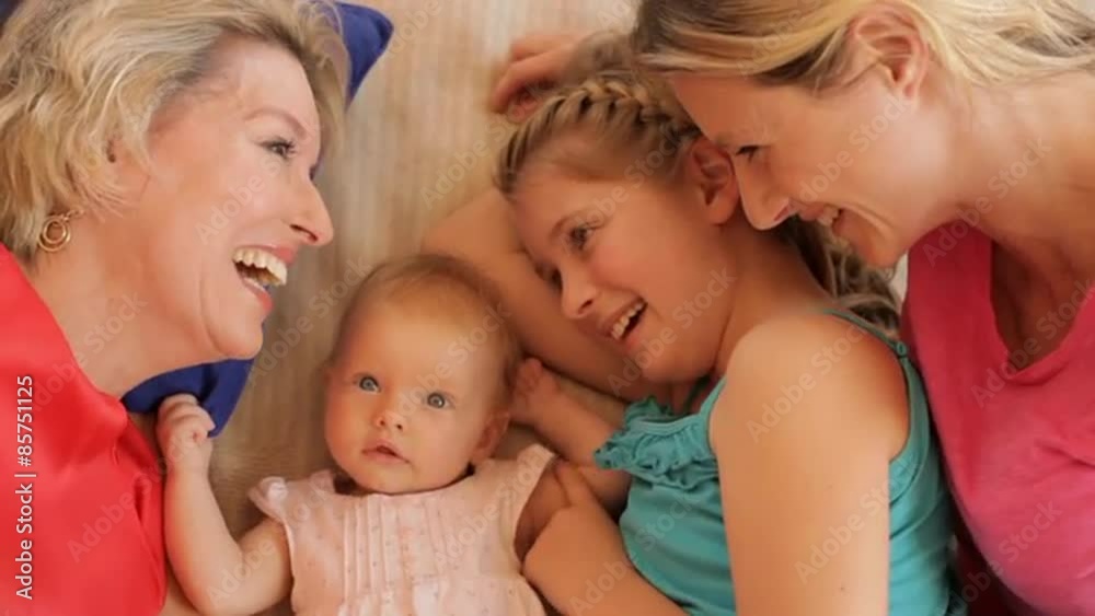 Four generations of females lying on rug together. Four generations of females lying on rug together.