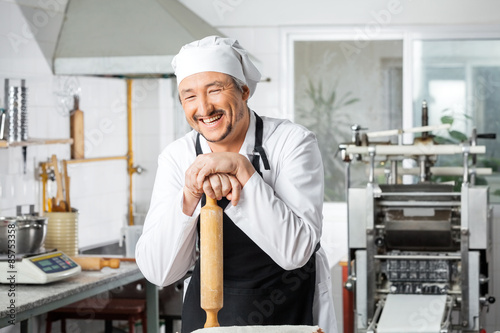 Cheerful Chef Leaning On Rolling Pin