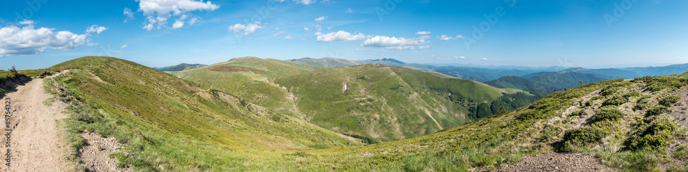 Spring mountains under blue sky with clouds - panoramic view
