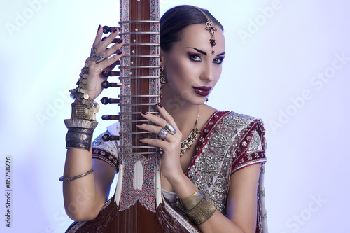 Beautiful Indian Woman in Sari with Oriental Jewelry Posing with