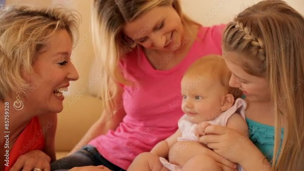 Four generations of females sitting on sofa together. Four generations of females sitting on sofa together.
