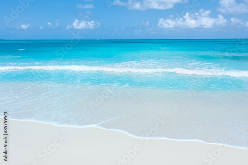 Turquoise waters and gentle waves on a white sand Caribbean beach. © rigelp