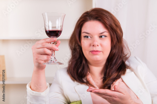 Woman at home tests glass of red wine