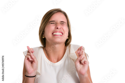 Hispanic young woman wishing luck with fingers crossed looking up. photo