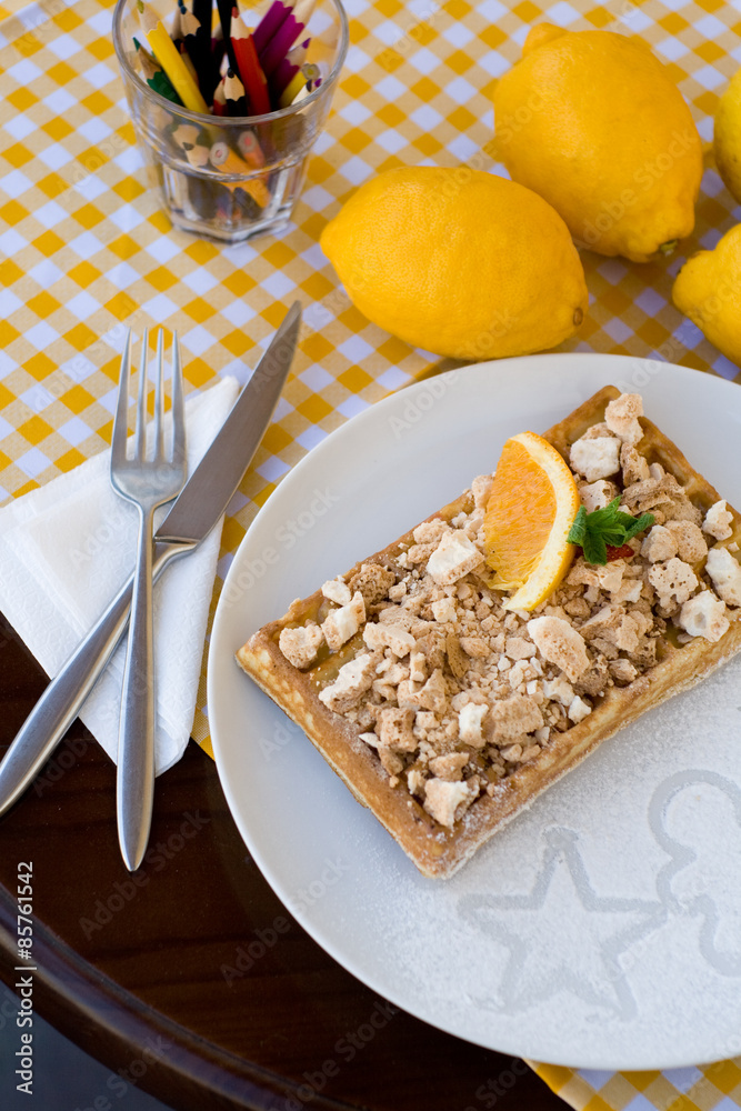 Waffles with meringue, lemon curls and orange slices Waffles with meringue, lemon curls and orange slices