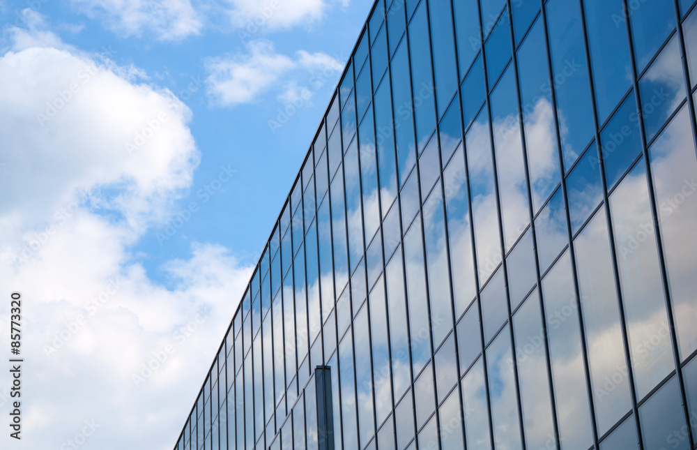 Reflection of the sky and clouds in Glass facade of a building in Poznan .