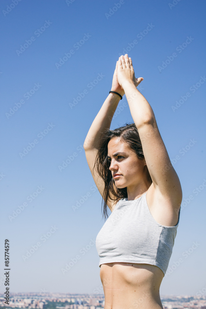Woman doing yoga in front of a city