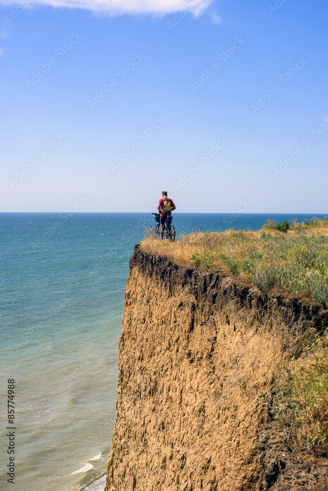 Obraz premium cyclist on a cliff above the sea