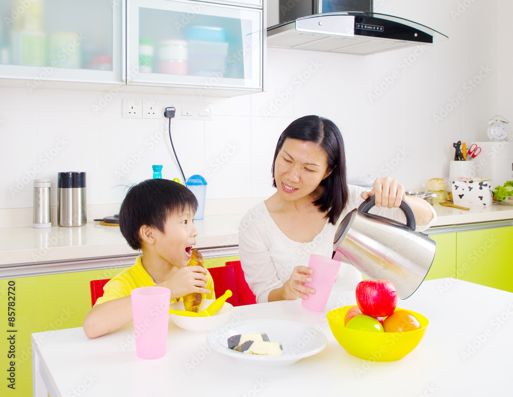 Happy asian family having breakfast in the kitchen Happy asian family having breakfast in the kitchen