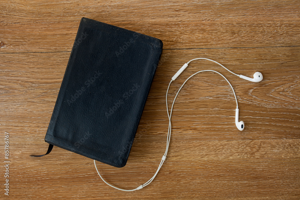 Contemporary image of a Bible with headphones. Hearing the voice Contemporary image of a Bible with headphones. Hearing the voice