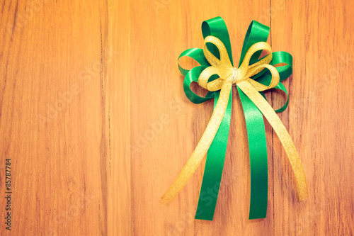 Ribbon bow on wood background. Retro filter.