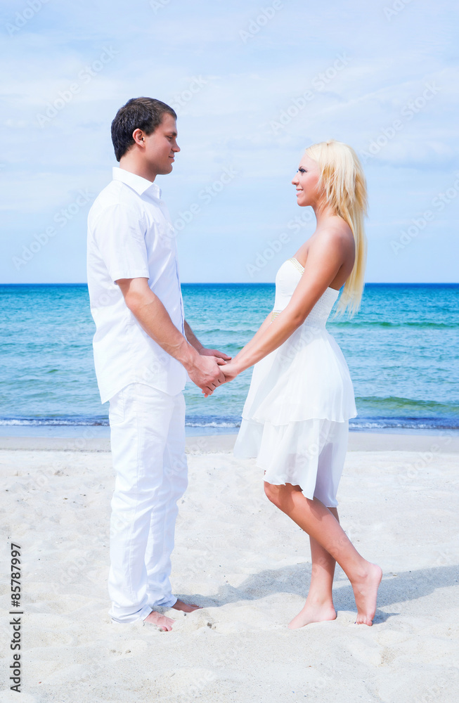 Loving couple walking and embracing on a tropical summer beach Loving couple walking and embracing on a tropical summer beach