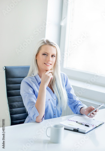 Young, attractive and confident business woman working in office photo