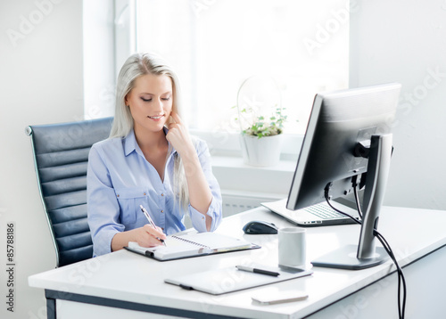 Young, attractive and confident business woman working in office