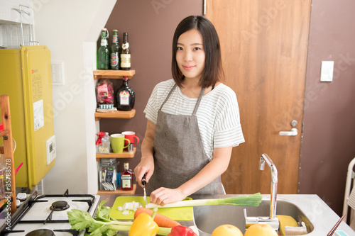 様々な野菜を切る若い女性