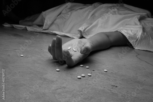 Foto Close-up on the floor of the drugs in hand of the dead body. In