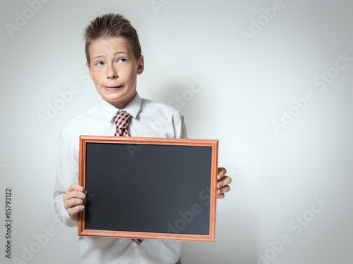 Funny schoolboy with empty chalkboard