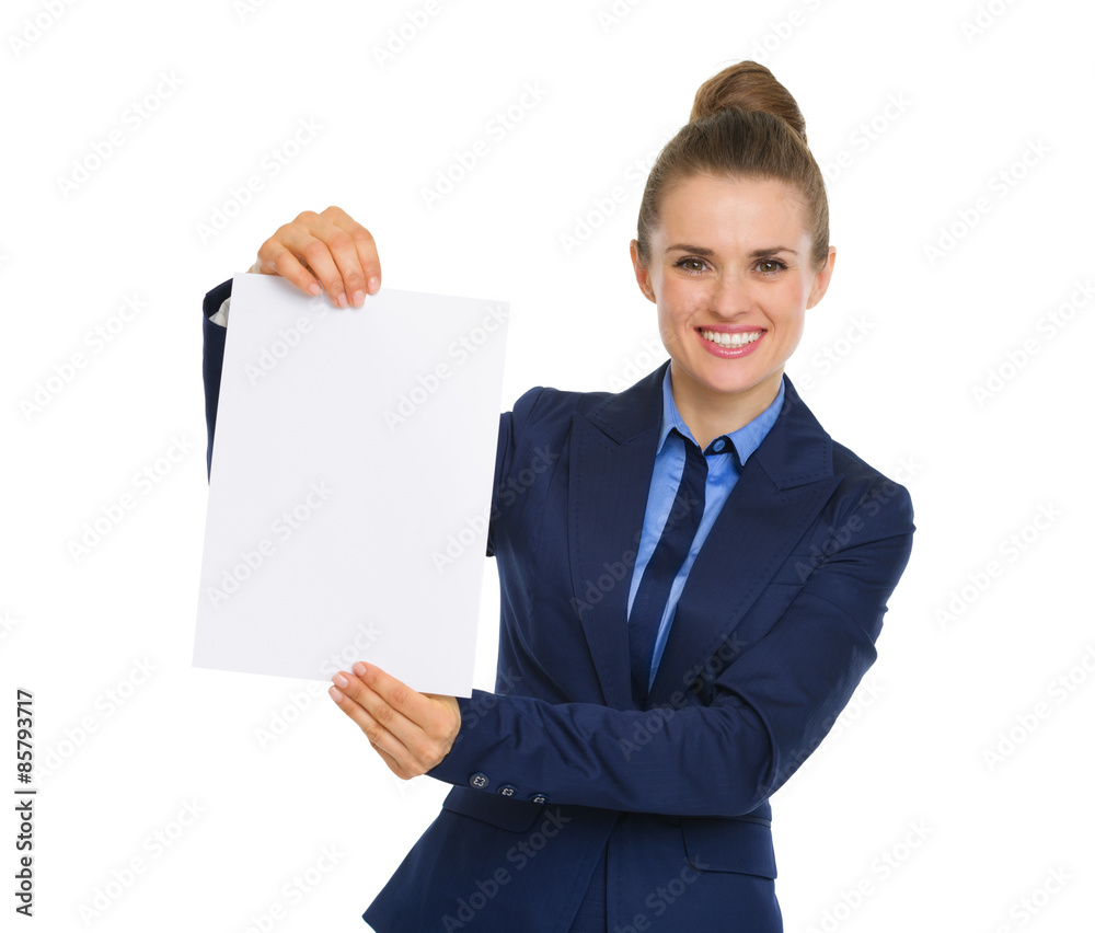 Businesswoman smiling and holding up a blank piece of paper Businesswoman smiling and holding up a blank piece of paper