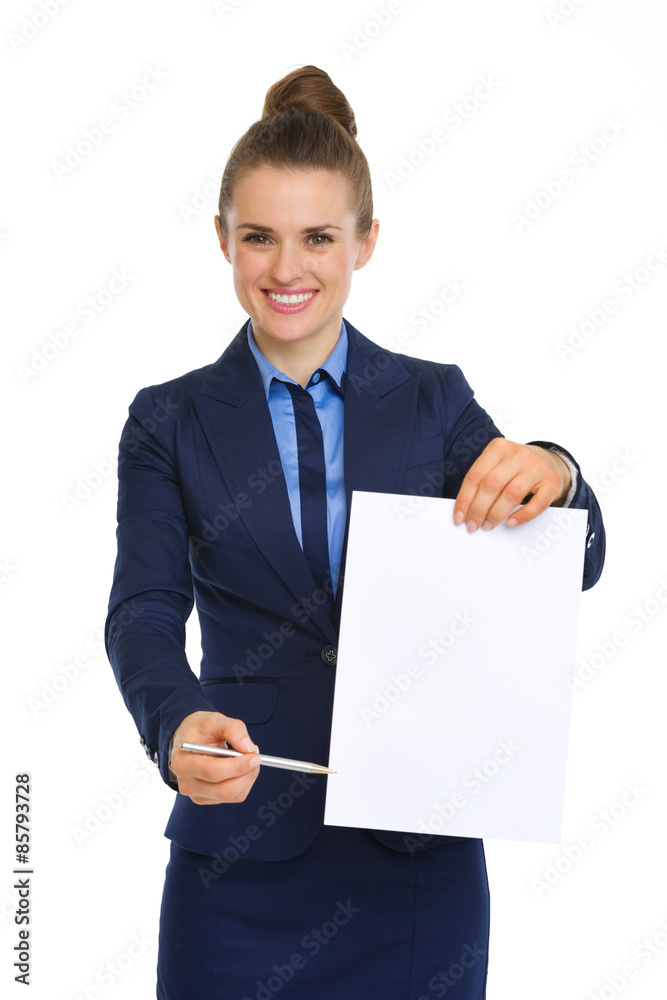 Businesswoman holding up blank paper, pointing with pen Businesswoman holding up blank paper, pointing with pen