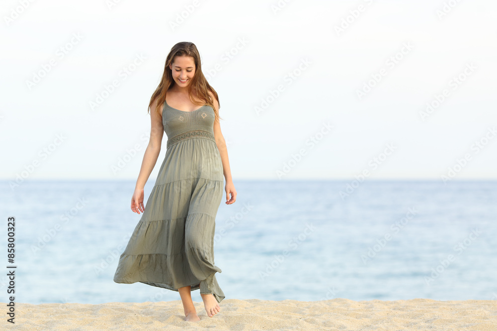 Candid dreamer girl walking on the sand of the beach