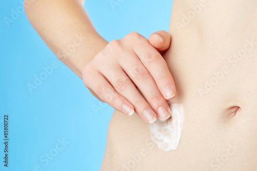 Woman applying moisturizer cream to her skin