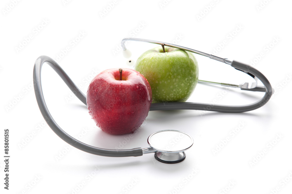 Protege tu salud con una comida sana: estetoscopio y manzana en fondo blanco Protege tu salud con una comida sana: estetoscopio y manzana en fondo blanco