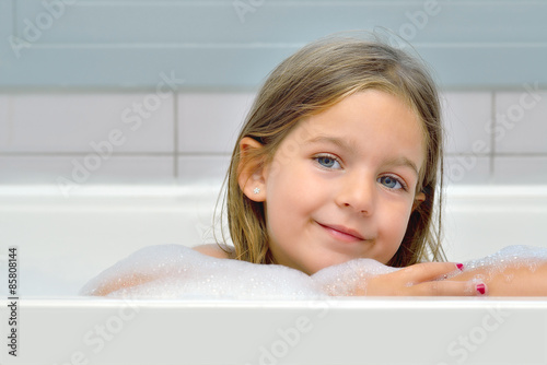Adorable toddler girl relaxing in bathtub
