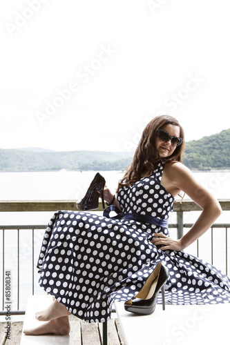 Frau in blauem Petticoat Kleid zeigt ihre Schuhe photo