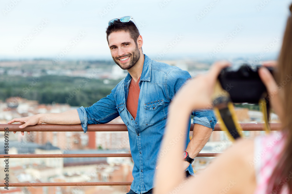 Young girl taking photo of her boyfriend.