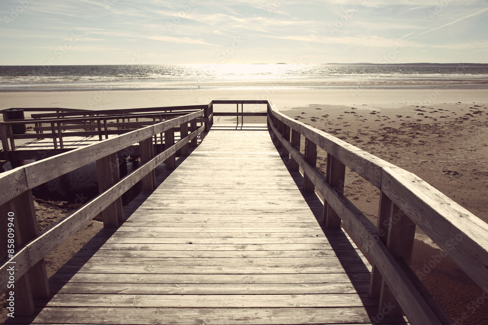 boardwalk to sandy beach and ocean with instagram filter effect