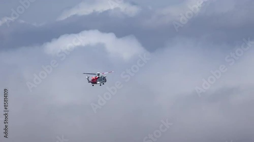 A Coast Guard helicopter hovers above a mountain in the Scottish Highlands, UK