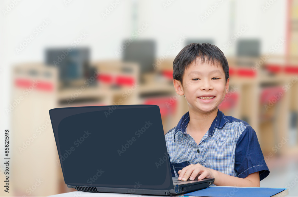 Little Asian boy using notebook computer Little Asian boy using notebook computer