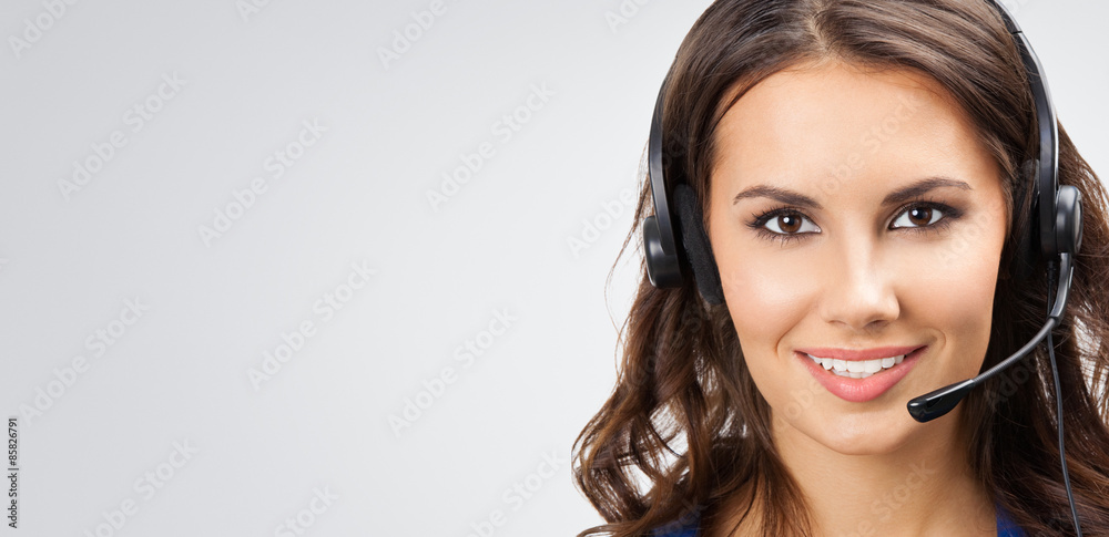 smiling young support phone operator, with copyspace, on grey smiling young support phone operator, with copyspace, on grey