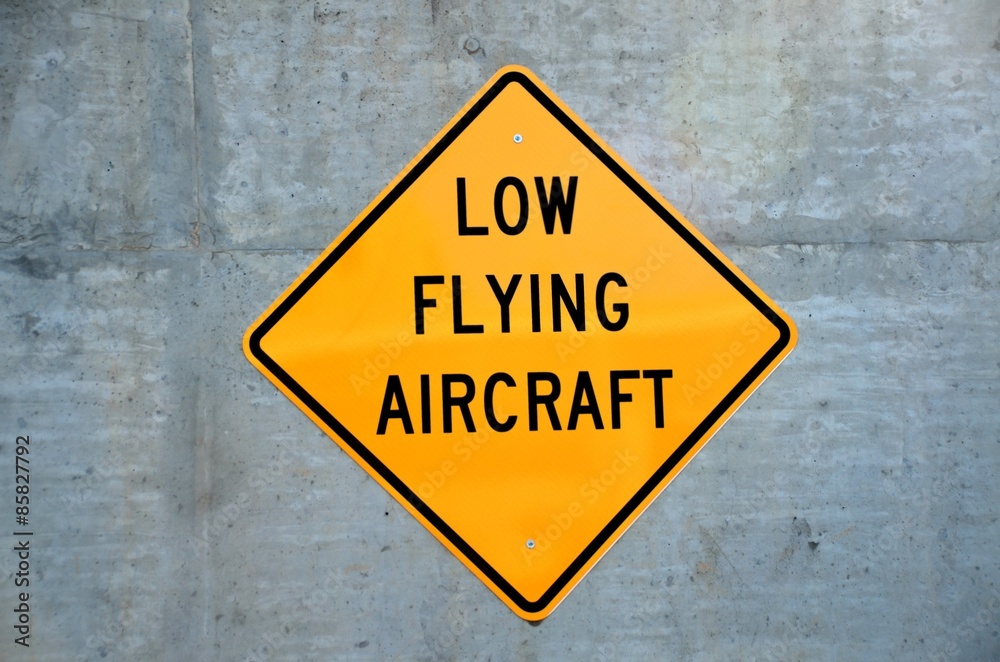 Low Flying Aircraft sign on cement wall background Low Flying Aircraft sign on cement wall background