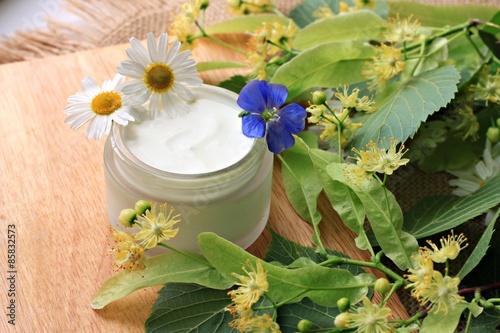 Fotografie jar of white facial herbal cream fresh blossom chamomile linden herbs