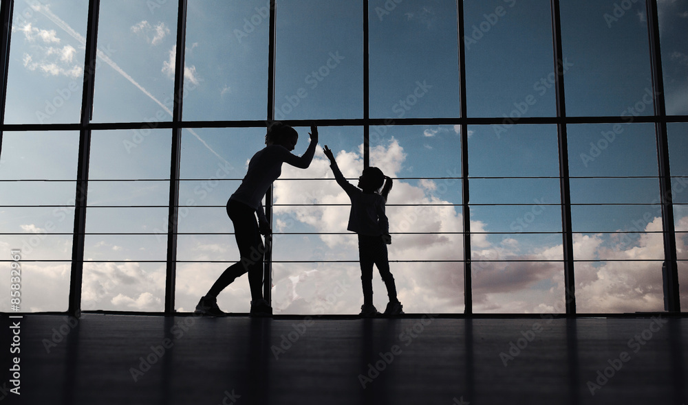 Silhouette of mother and daughter in the gym