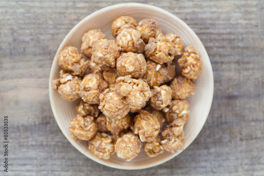Almond and caramal popcorn on wood background Almond and caramal popcorn on wood background