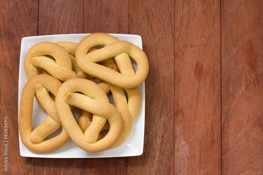 cookies in plate on brown wooden background