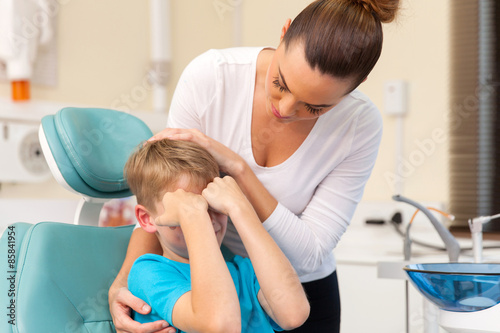 mother comforting her son in dentist office