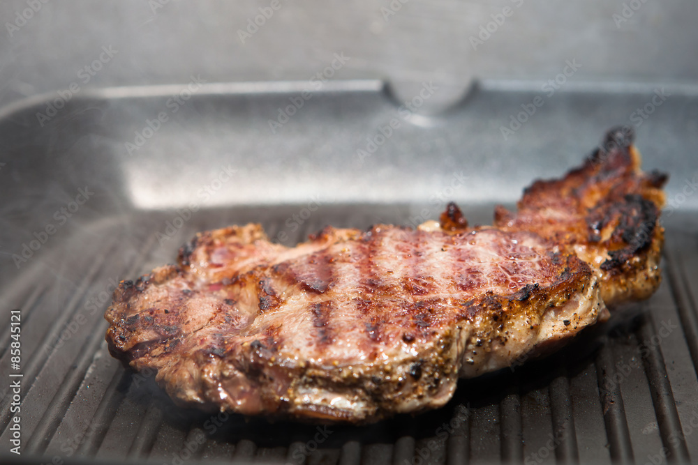 frying beef steak on a ribbed grill pan frying beef steak on a ribbed grill pan