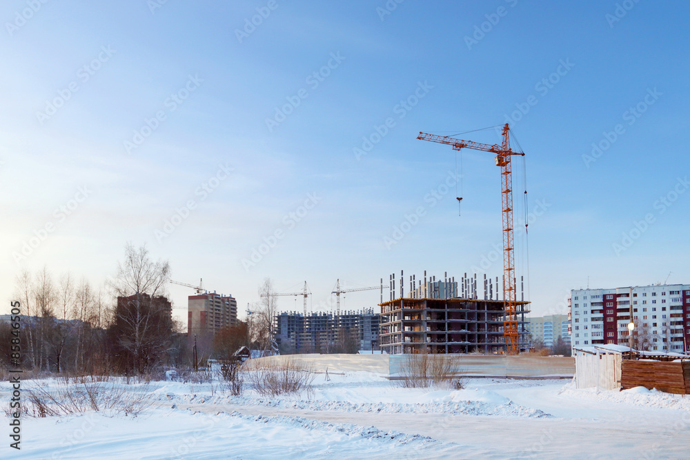 Large apartment buildings under construction in winter sunny day