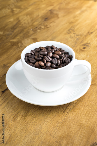 Cup full of coffee beans on the table