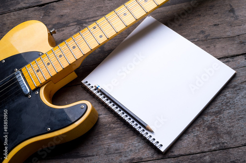 Telecaster electric guitar with notepad on wood desk