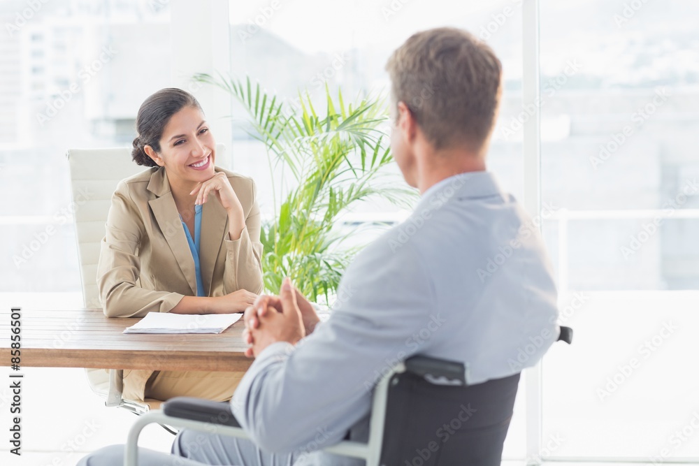 Smiling businesswoman interviewing disabled candidate Smiling businesswoman interviewing disabled candidate