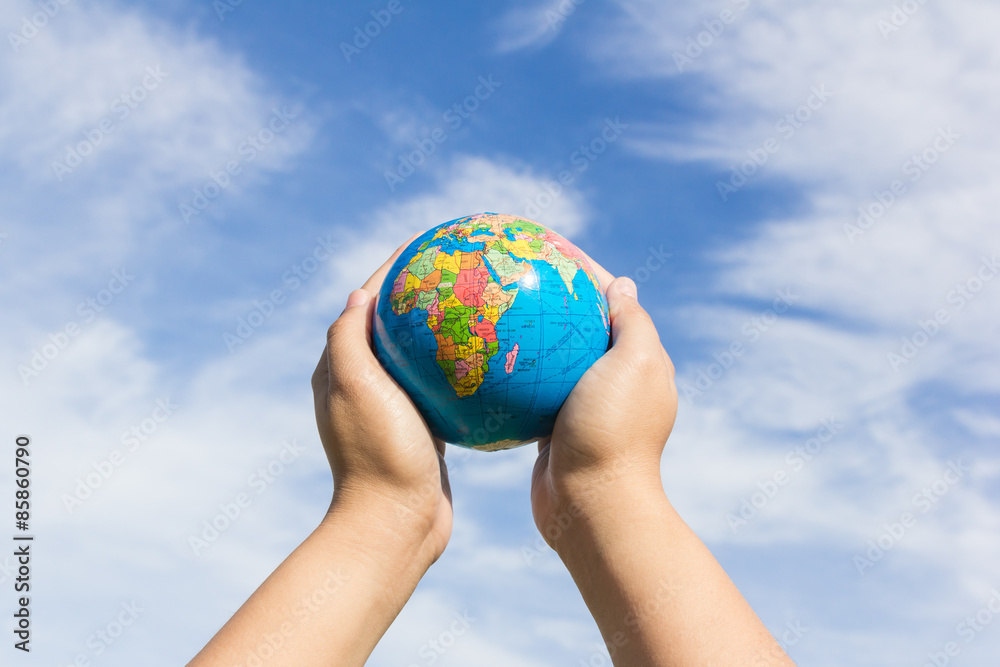 hands holding globe with sky background hands holding globe with sky background