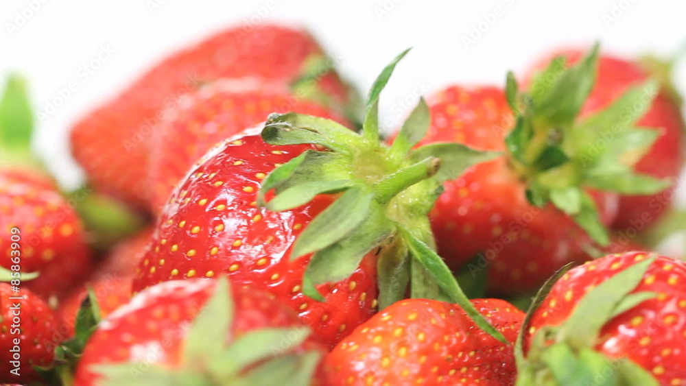 Fresh organic Strawberries in a bowl shot close-up while rotating in a seamless loop on white background Fresh organic Strawberries in a bowl shot close-up while rotating in a seamless loop on white background